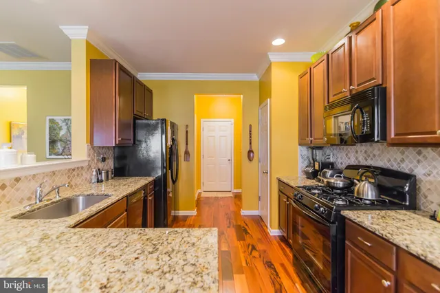 a kitchen with stainless steel appliances granite countertop a sink a stove and a refrigerator
