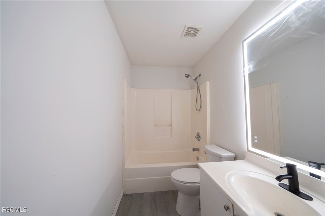 4306 11th Street Southwest Lehigh Acres, FL 33976 - Photo 12 of 17 a bathroom with a sink a toilet and shower