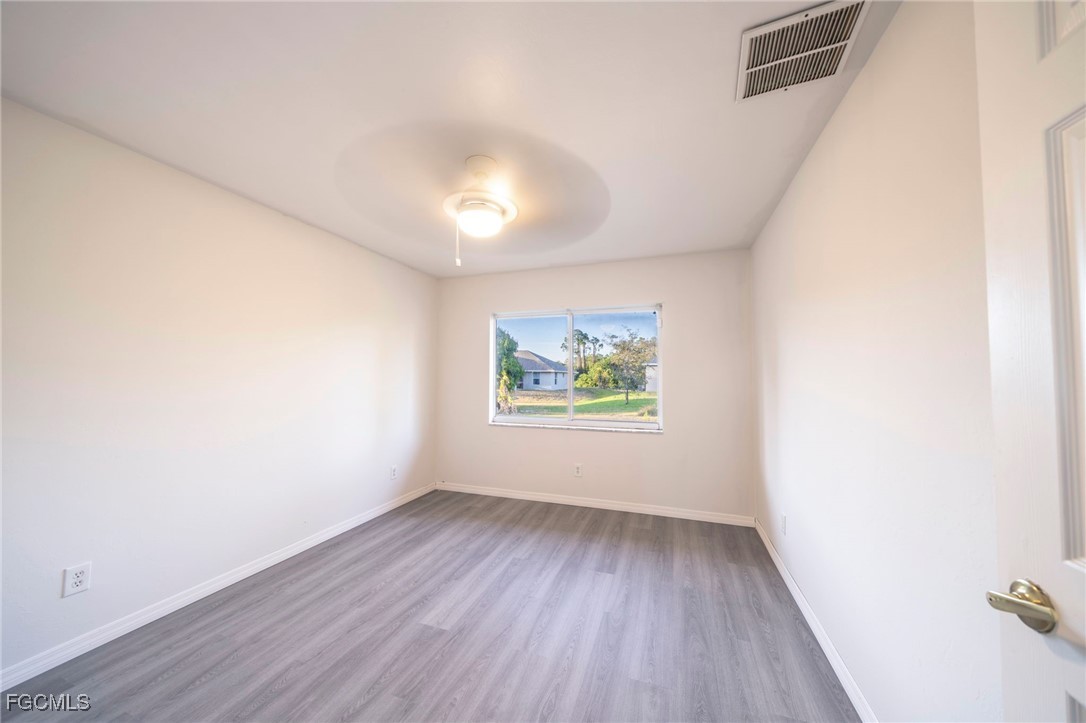 4306 11th Street Southwest Lehigh Acres, FL 33976 - Photo 13 of 17 an empty room with wooden floor and window