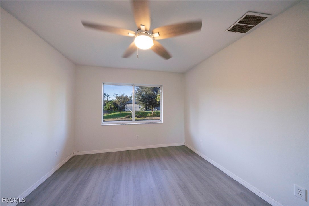 4306 11th Street Southwest Lehigh Acres, FL 33976 - Photo 14 of 17 an empty room with wooden floor and windows