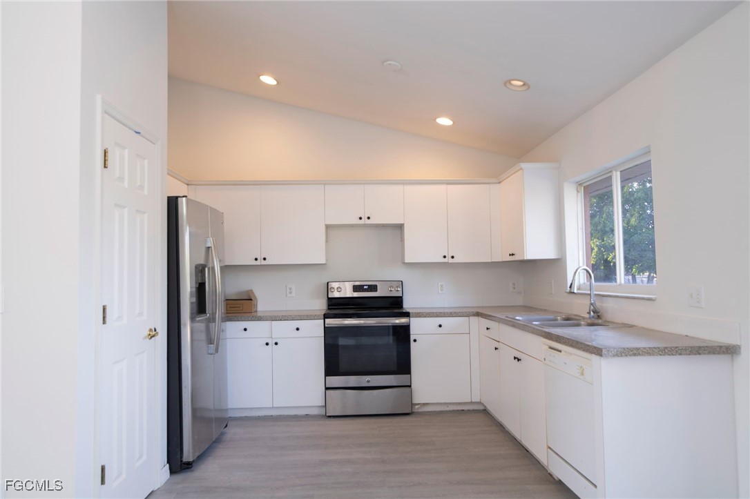 4306 11th Street Southwest Lehigh Acres, FL 33976 - Photo 5 of 17 a kitchen with stainless steel appliances a sink stove and refrigerator