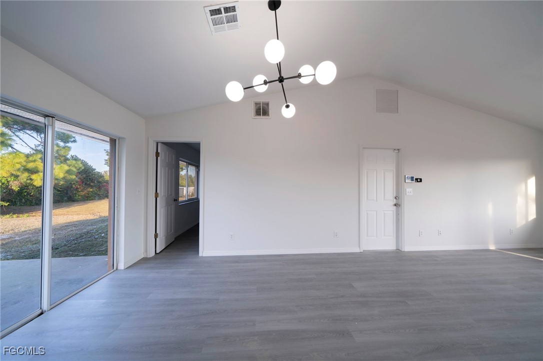 4306 11th Street Southwest Lehigh Acres, FL 33976 - Photo 7 of 17 a view of an empty room with wooden floor and a window