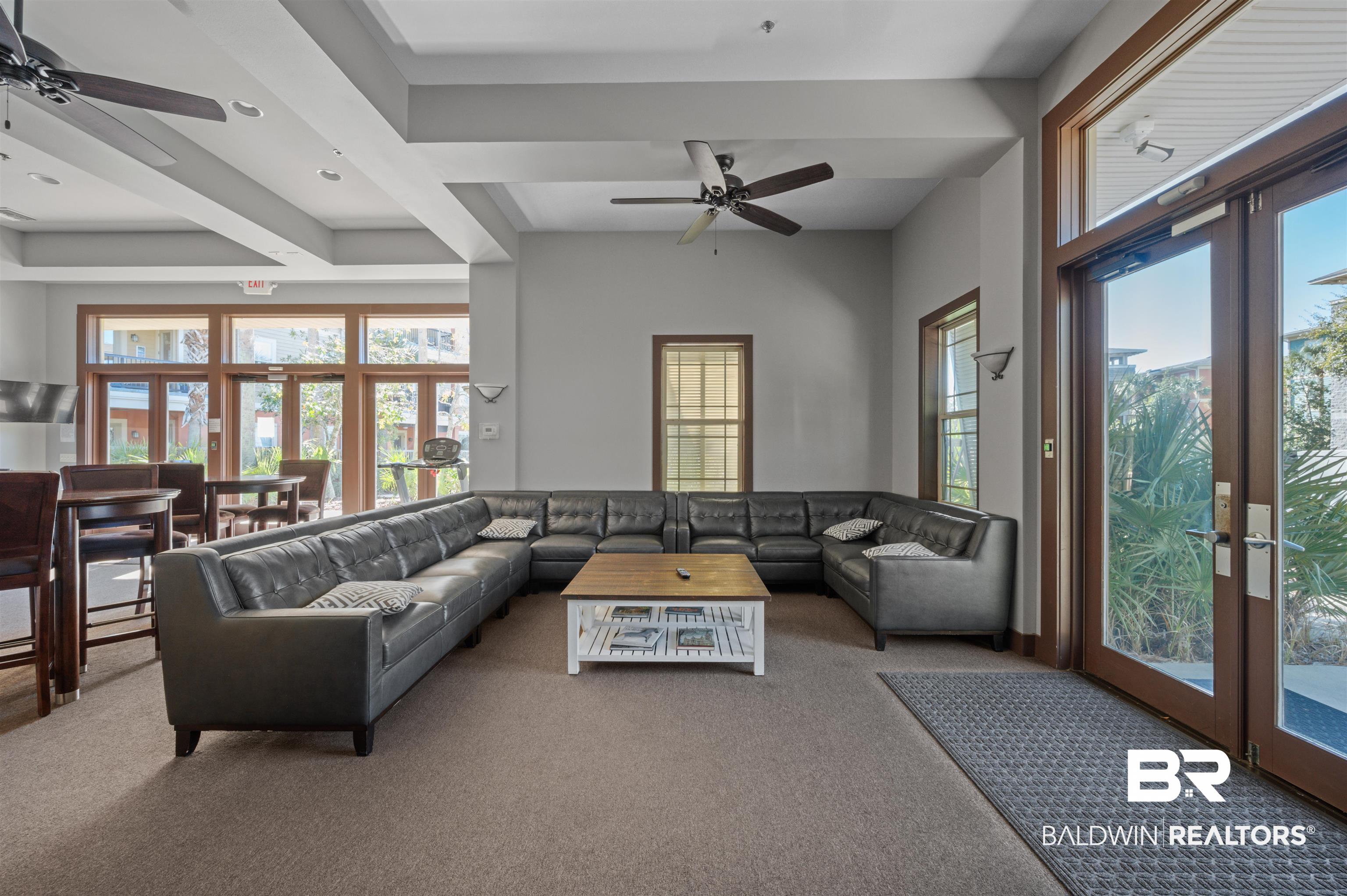 1430 Regency Road, Unit B202 Gulf Shores, AL 36542 - Photo 28 of 33 Living area featuring carpet floors, plenty of natural light, and a ceiling fan