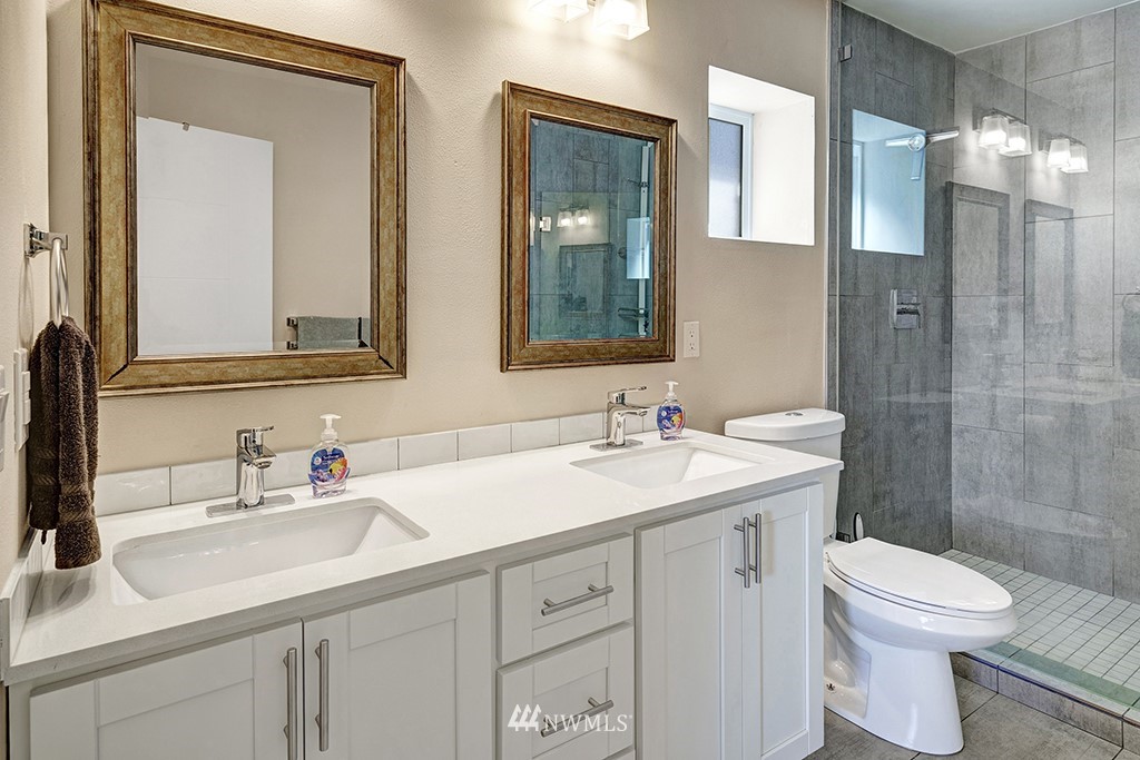 11225 Southeast 22nd Street Renton, WA 98055 - Photo 16 of 28 a bathroom with a toilet a sink a mirror a shower a vanity and window