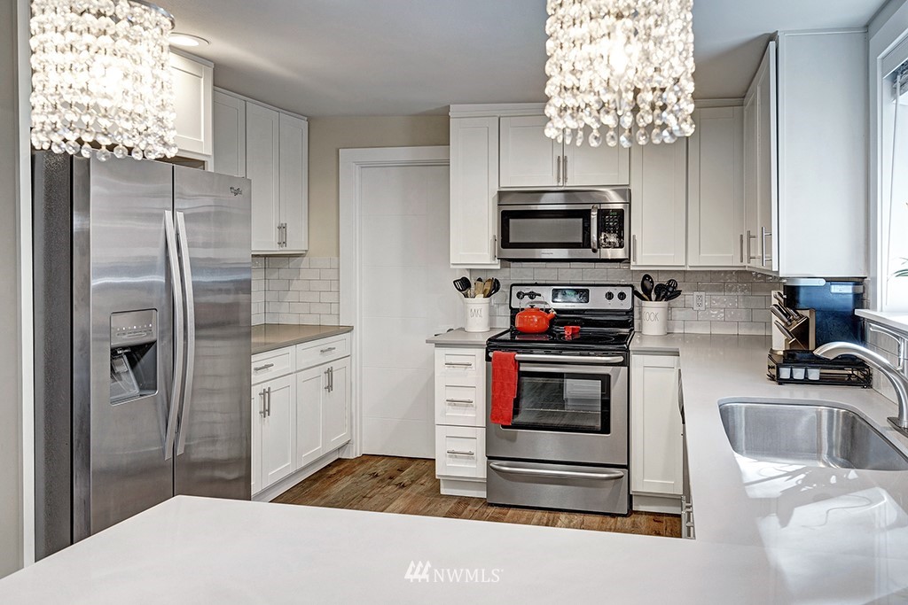 11225 Southeast 22nd Street Renton, WA 98055 - Photo 10 of 28 a kitchen with granite countertop a refrigerator stove and microwave