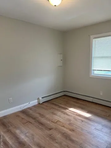 a view of a room with wooden floor and window