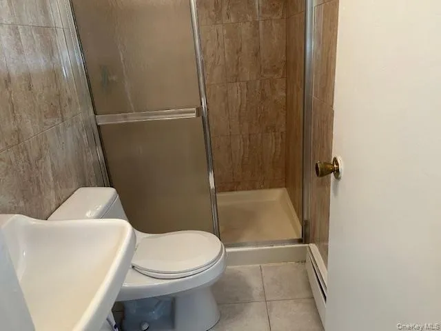 a white toilet sitting next to a shower