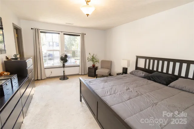a spacious bedroom with a bed and glass windows