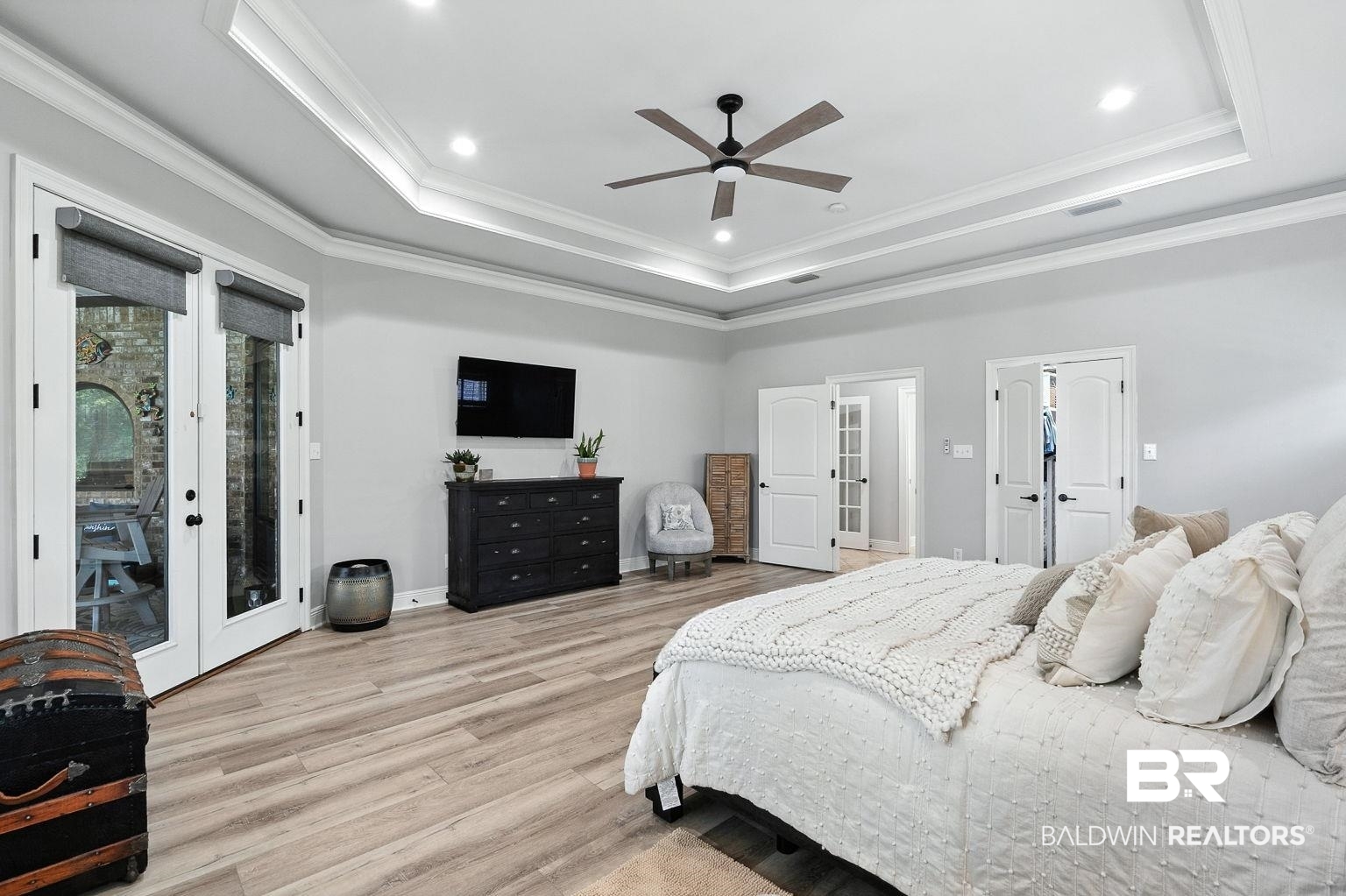 23357 Carnoustie Drive Foley, AL 36535 - Photo 49 of 99 Bedroom with a tray ceiling, french doors, access to exterior, wood finished floors, and crown molding