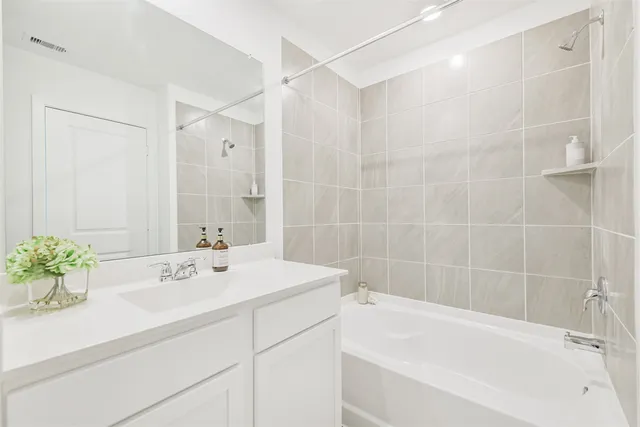 a bathroom with a sink tub shower and a mirror