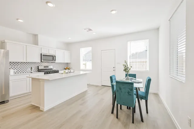 a kitchen with white cabinets and white appliances