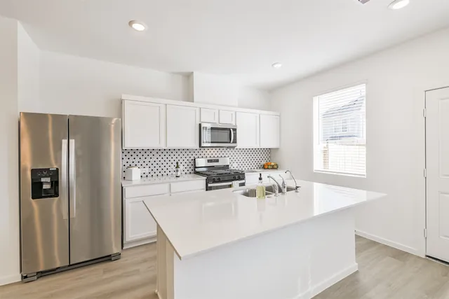 a kitchen with stainless steel appliances a sink stove and refrigerator