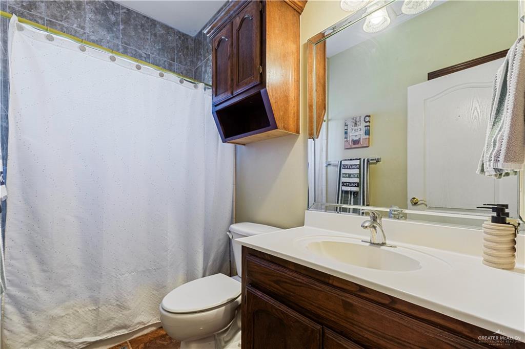 10675 Texan Road Mission, TX 78574 - Photo 12 of 23 a bathroom with a granite countertop sink toilet and mirror