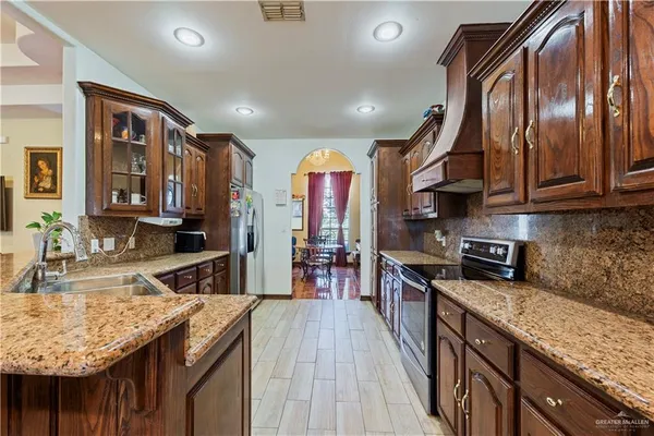 a kitchen with stainless steel appliances granite countertop a sink stove and refrigerator