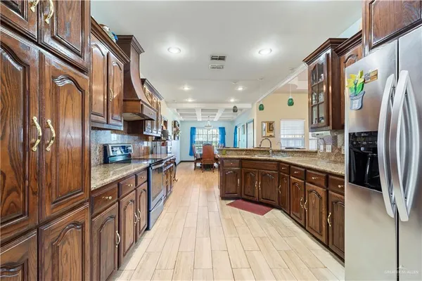 a kitchen with stainless steel appliances granite countertop lots of counter top space and wooden floor