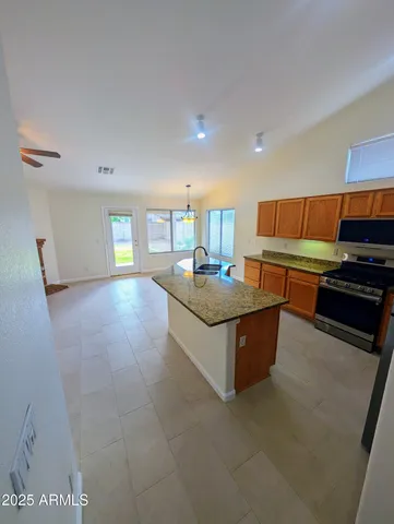 an empty room with windows and chandelier fan