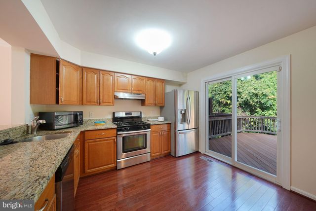 a kitchen with granite countertop wooden floors and stainless steel appliances