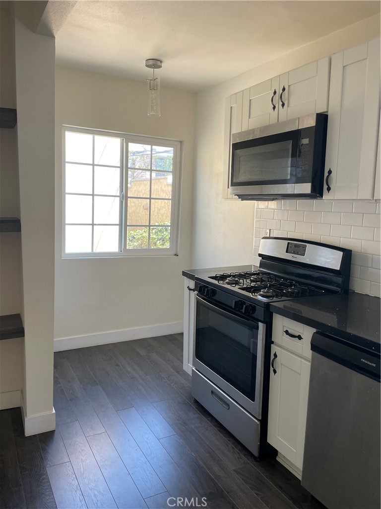 1325 1/2 Douglas Street Los Angeles, CA 90026 - Photo 5 of 23 a kitchen with granite countertop a stove and a microwave