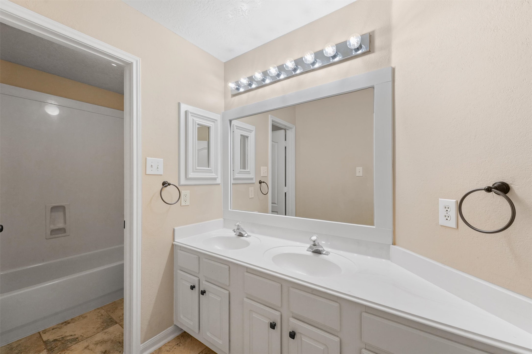 6803 Rhodes Court Missouri City, TX 77459 - Photo 7 of 13 a bathroom with a double vanity sink a toilet a shower and a mirror