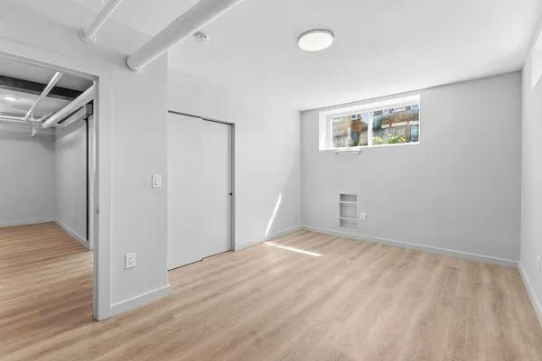 an empty room with wooden floor and closet