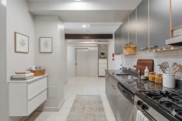 a kitchen with sink a stove and cabinets