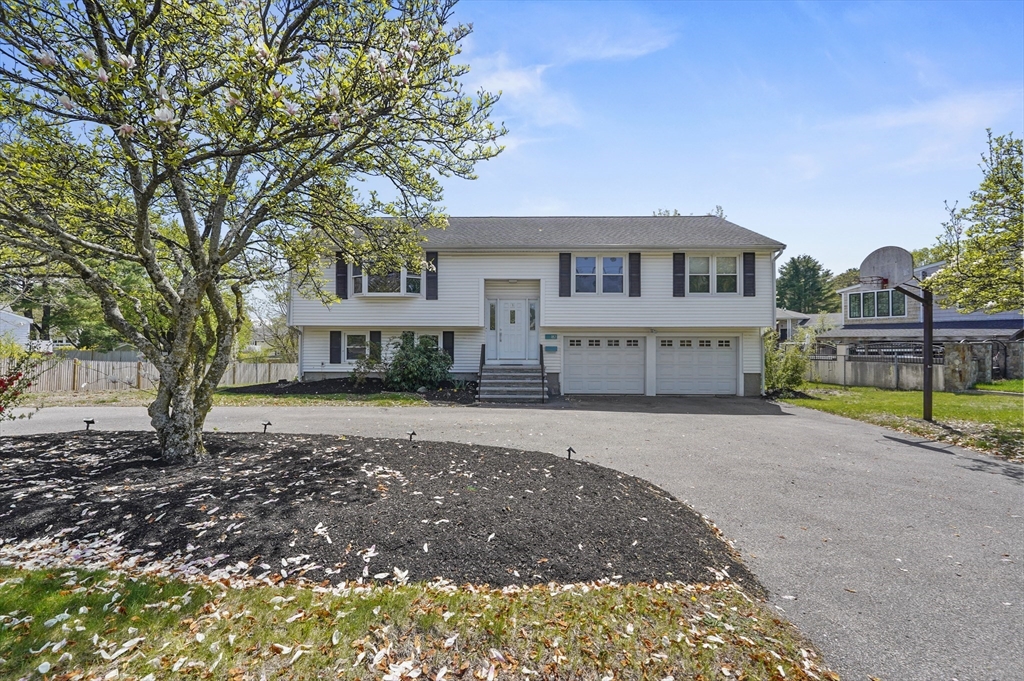 182 Needham Street Dedham, MA 02026 - Photo 1 of 33 a front view of a house with a yard and garage