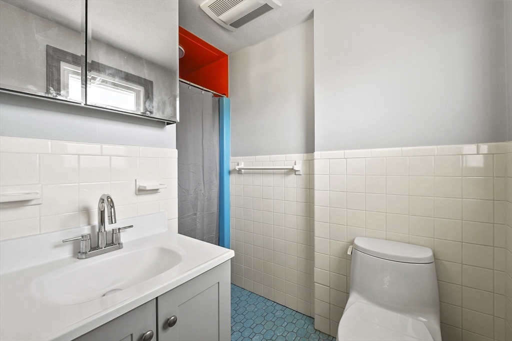 182 Needham Street Dedham, MA 02026 - Photo 12 of 33 a bathroom with a sink a toilet and a mirror