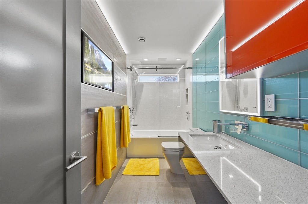 182 Needham Street Dedham, MA 02026 - Photo 15 of 33 a bathroom with a tub a sink and a large mirror