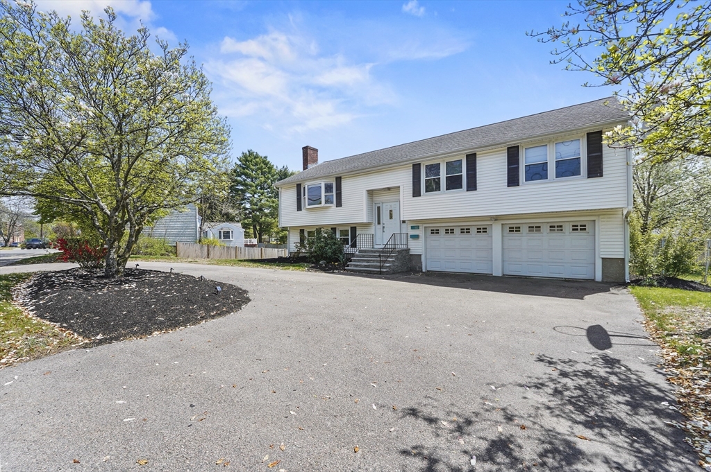 182 Needham Street Dedham, MA 02026 - Photo 28 of 33 a front view of a house with a yard and garage