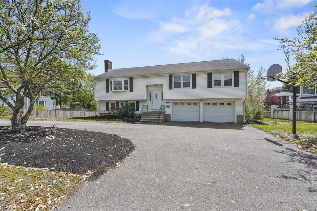 182 Needham Street Dedham, MA 02026 - Photo 29 of 33 a front view of a house with a yard and garage
