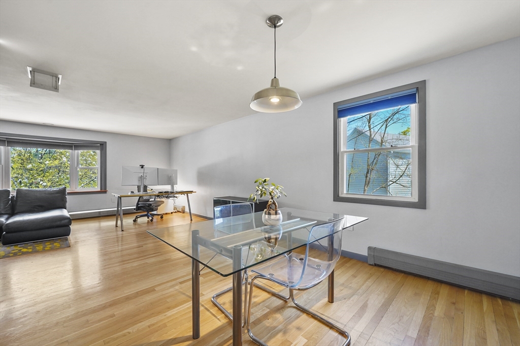 182 Needham Street Dedham, MA 02026 - Photo 6 of 33 a dining room with wooden floor a chandelier a glass table and chairs
