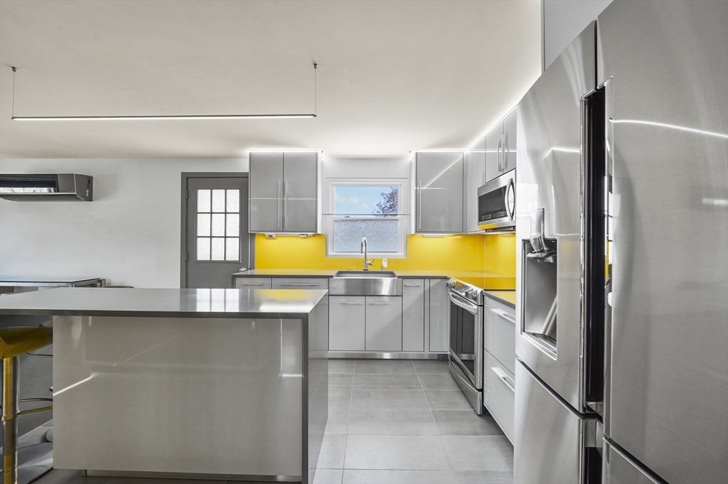 182 Needham Street Dedham, MA 02026 - Photo 10 of 33 a kitchen with stainless steel appliances a refrigerator and a stove