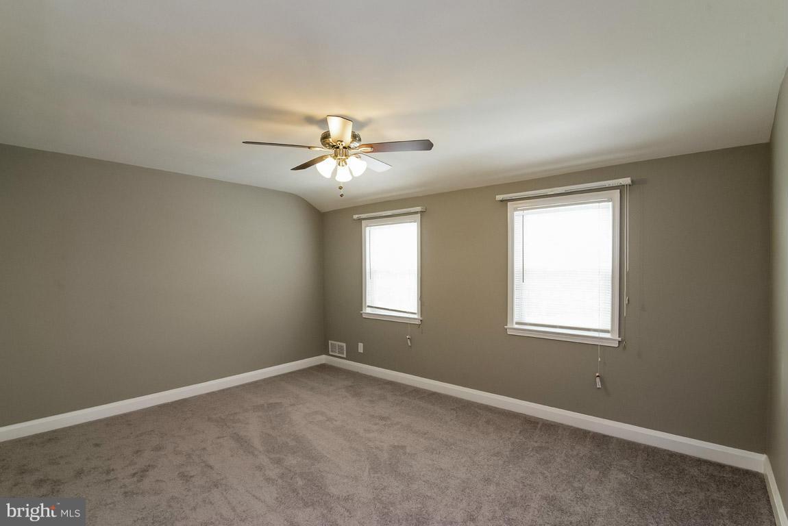 718 Middlesex Road Baltimore, MD 21221 - Photo 13 of 30 an empty room with a chandelier fan and windows