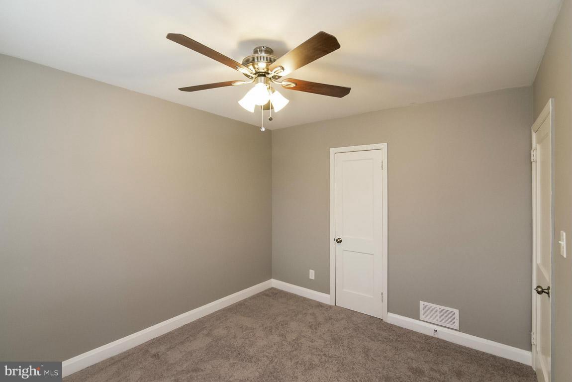 718 Middlesex Road Baltimore, MD 21221 - Photo 19 of 30 an empty room with windows and fan