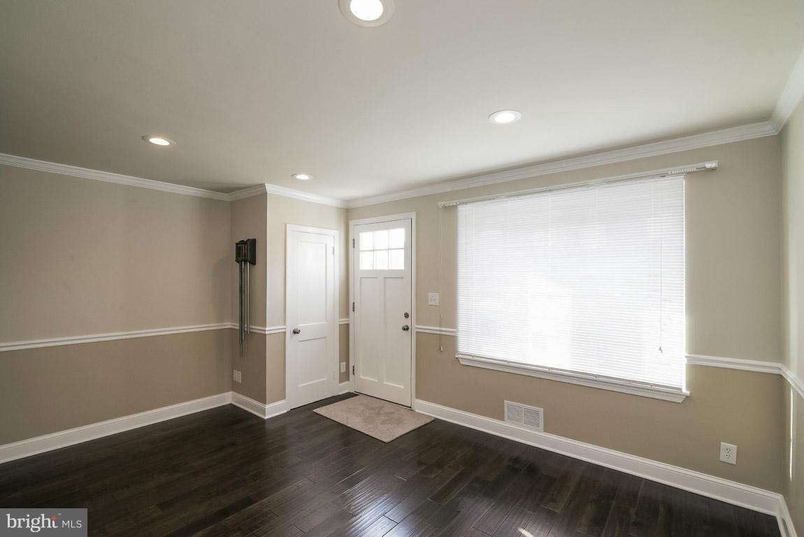 718 Middlesex Road Baltimore, MD 21221 - Photo 4 of 30 a view of an empty room with wooden floor and a window