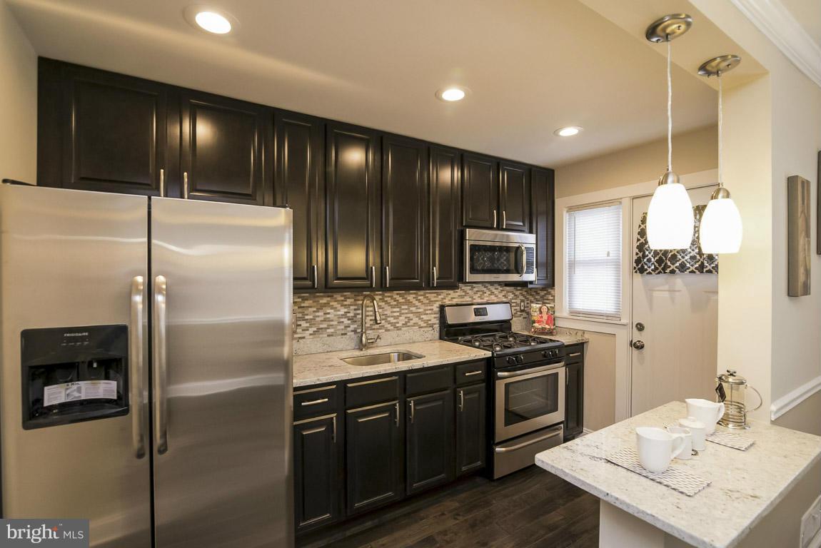 718 Middlesex Road Baltimore, MD 21221 - Photo 5 of 30 a kitchen with a sink stainless steel appliances and cabinets