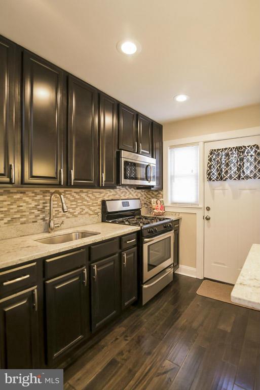 718 Middlesex Road Baltimore, MD 21221 - Photo 6 of 30 a kitchen with granite countertop stainless steel appliances and wooden cabinets