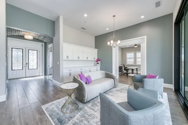 a living room with stainless steel appliances furniture a fireplace and a flat screen tv