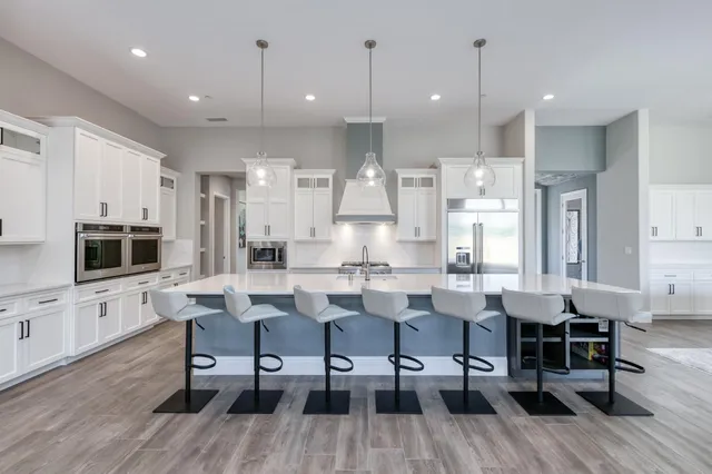 a kitchen with stainless steel appliances granite countertop a refrigerator a sink and a stove