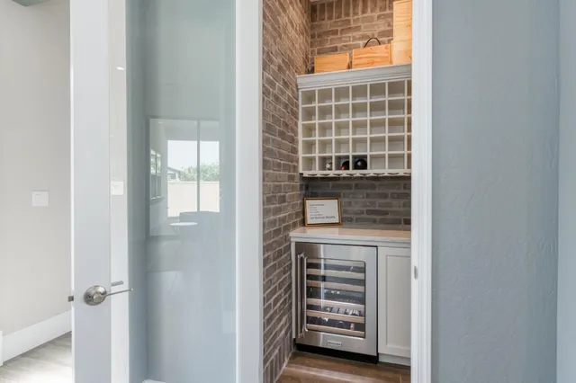 a living room with stainless steel appliances furniture a rug and a kitchen view