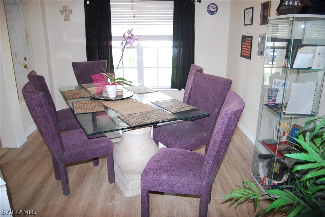 18561 Olive Road Fort Myers, FL 33967 - Photo 4 of 35 a view of a dining room with furniture a potted plant and wooden floor
