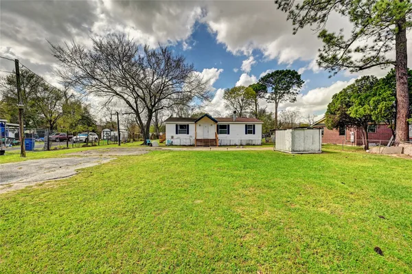a view of a house with a big yard and large trees