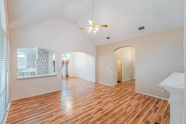 a view of a livingroom with wooden floor and a large window