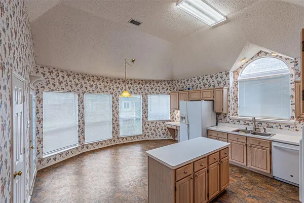 a kitchen that has a stove a sink and a refrigerator