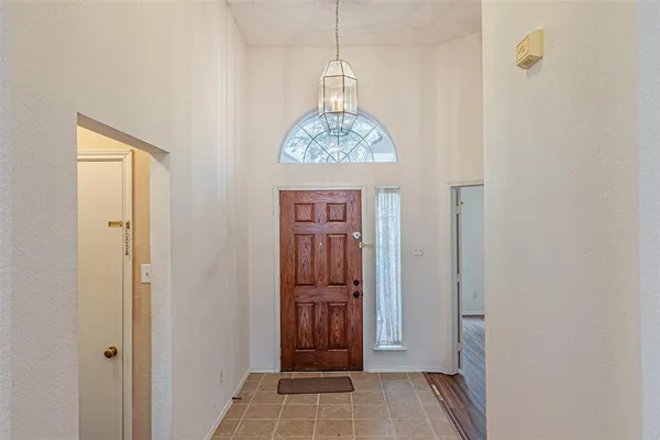 a view of a hallway with windows and chandelier