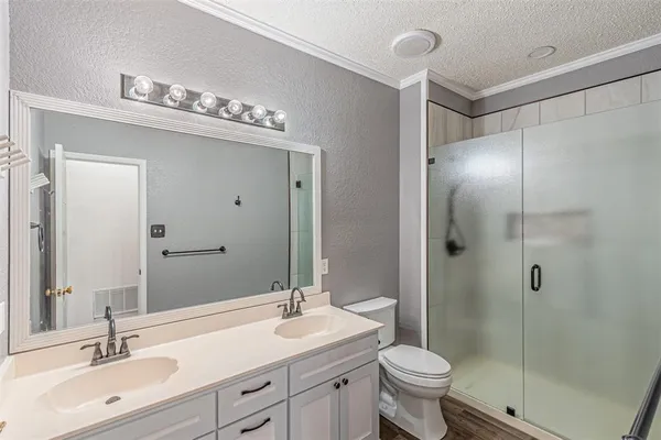 a bathroom with a sink a toilet and shower