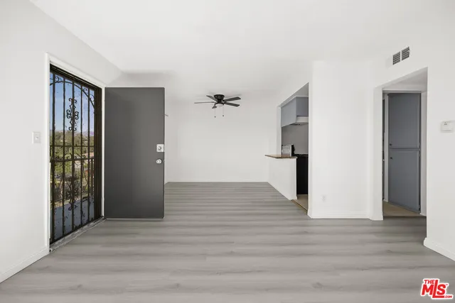 a view of a big room with wooden floor and windows
