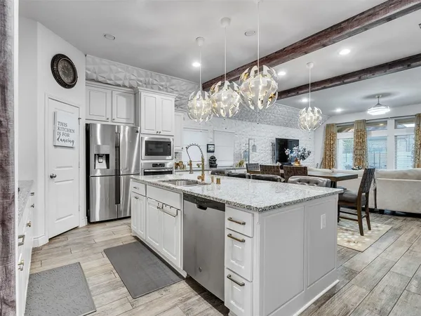 a kitchen with stainless steel appliances granite countertop a sink and refrigerator