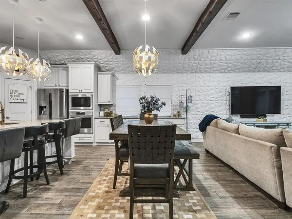 a view of a dining room with furniture a rug and wooden floor