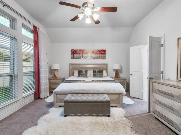 a bedroom with a large bed and a chandelier